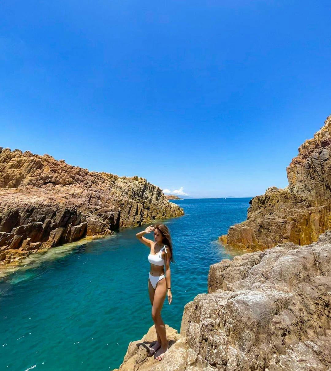 nature outdoors cliff promontory sea water person shoreline clothing bikini