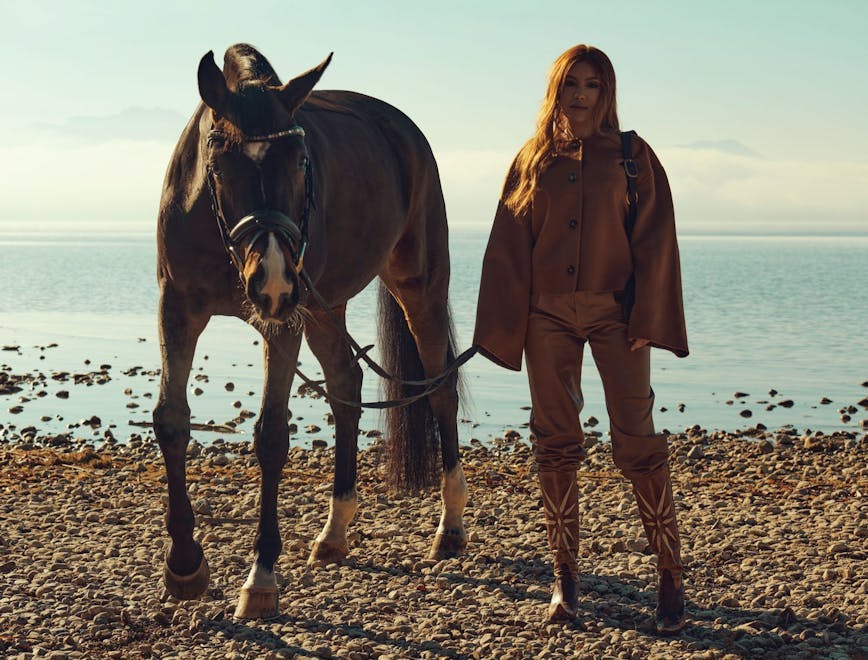 coat clothing person beach water shoreline horse mammal animal horseback riding